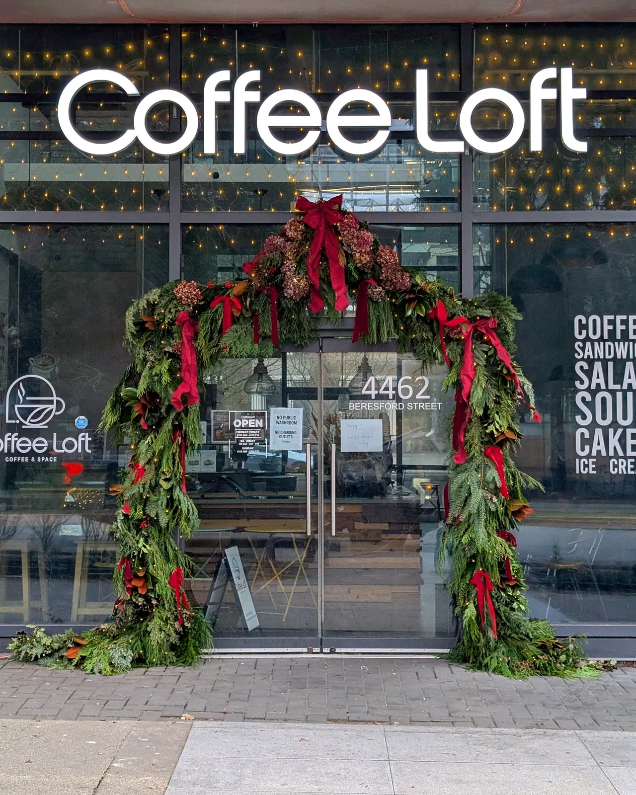 Christmas archway of cedar, magnolia, hydrangeas and red velvet ribbon at Coffee Loft, Burnaby, by Hart Veritas