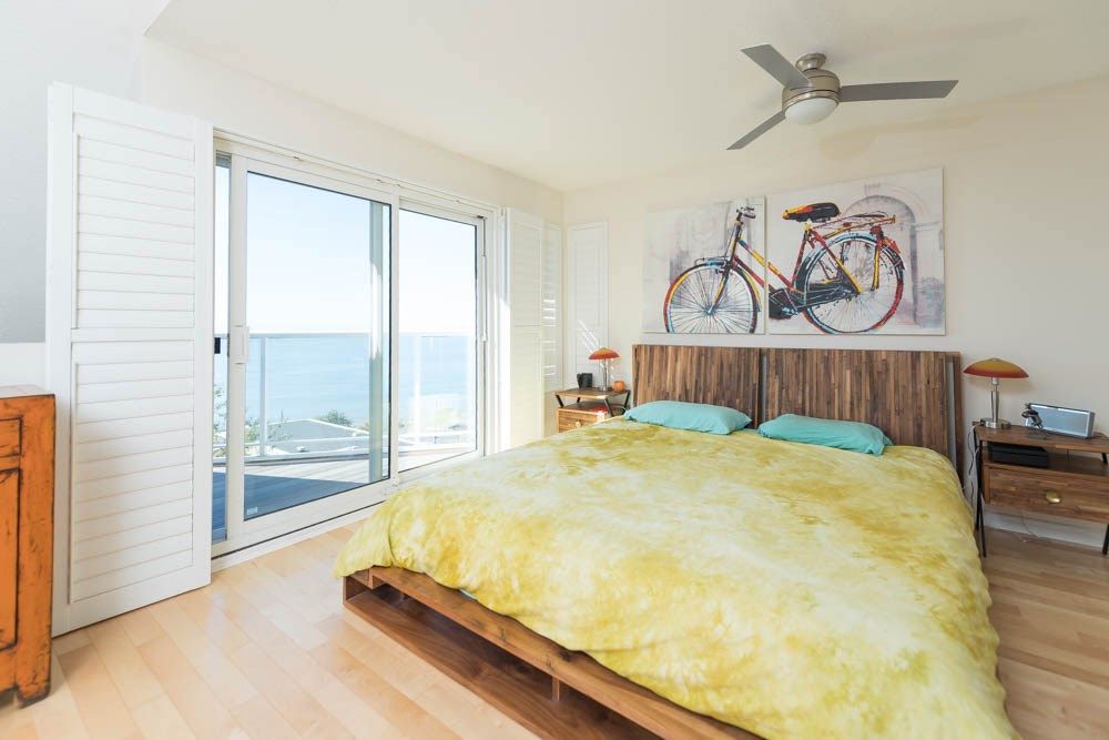 White Rock — existing bedroom with yellow bedding and bicycle art before renovation