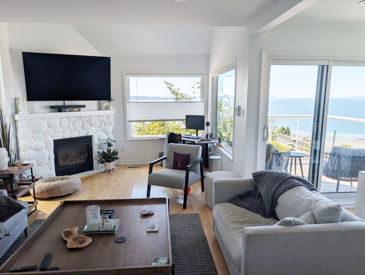 White Rock living room — white stone fireplace with ocean view beyond
