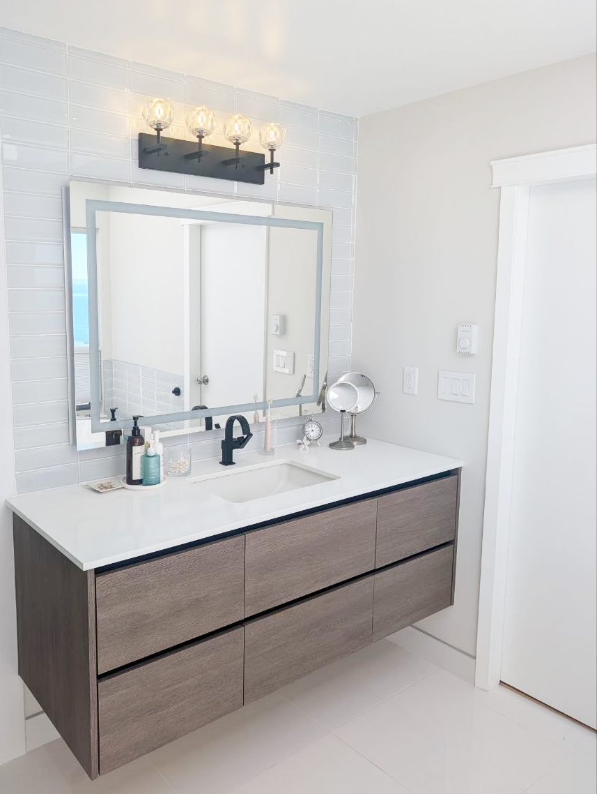 White Rock ensuite — floating vanity with quartz counter, matte black fixtures, and white subway tile