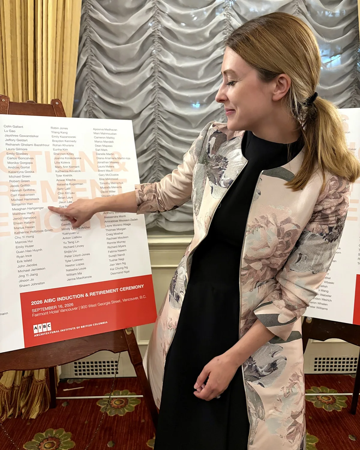 Meaghan Hartgenger pointing to her name on the list of 2026 AIBC inductees.