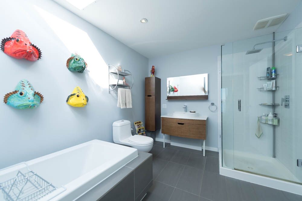 White Rock — existing ensuite with dated tub surround and decorative wall fish before renovation
