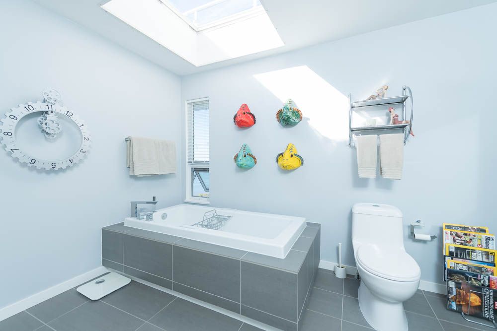 White Rock — existing ensuite with built-in tub, gear clock, and wall fish before renovation
