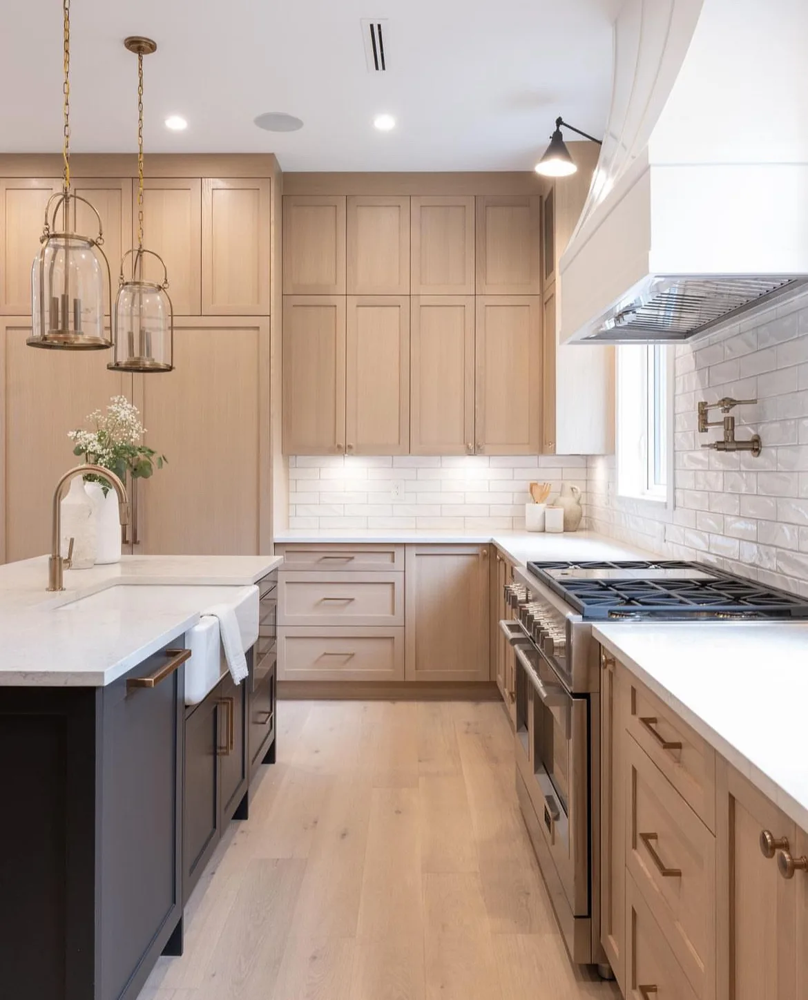 Tsawwassen Residence — kitchen with white oak cabinetry, navy island, and brass fixtures